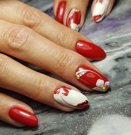 Manucure rouge à fleurs blanches