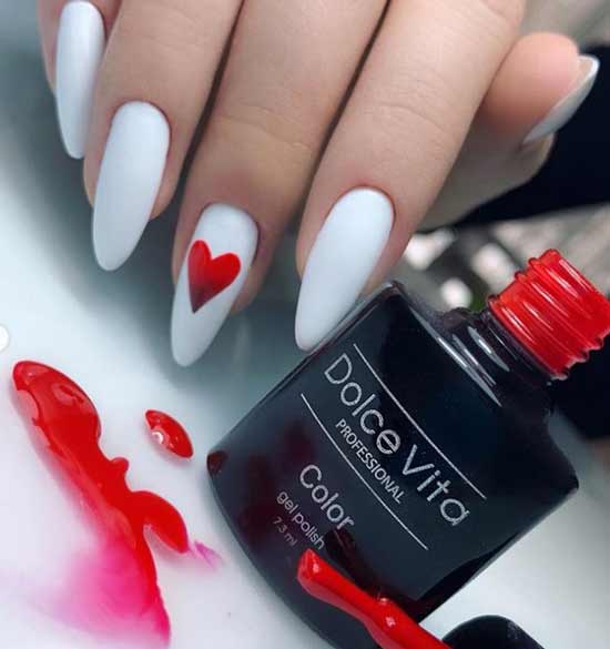 Ongles longs blancs avec un coeur rouge