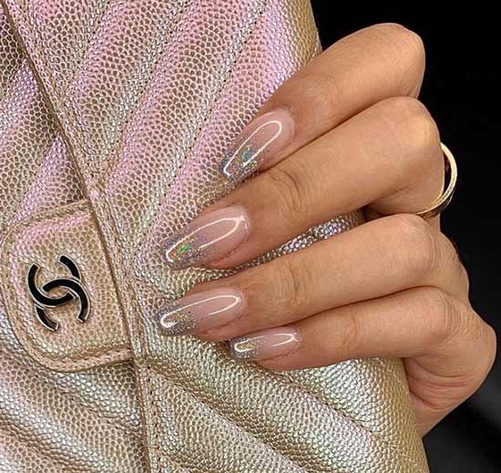 Paillettes sur les pointes de l'ongle sur une base transparente