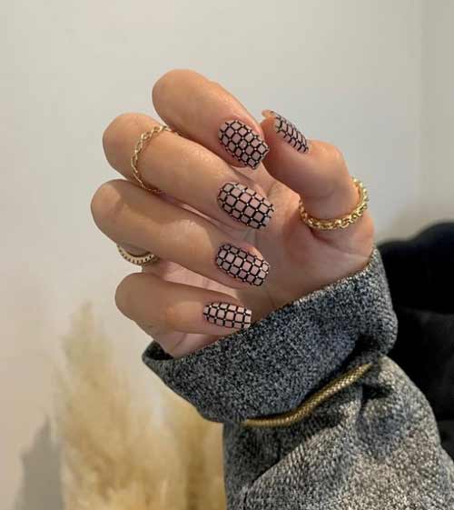 Cage noire et blanche à la mode sur des ongles